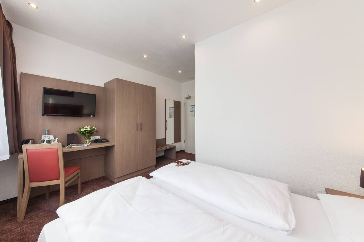 Ropa de cama hipoalergénica y caja de seguridad en la habitación 