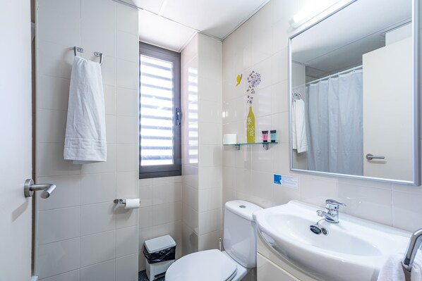 A bathroom with a toilet, sink, and towel rack. - Residencia Universitaria Resa Giner de los Ríos - Hostel (Alcala de Henares)