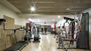 A gym with treadmills, weight machines, and a punching bag. - Residencia Universitaria Resa Giner de los Ríos - Hostel (Alcala de Henares)
