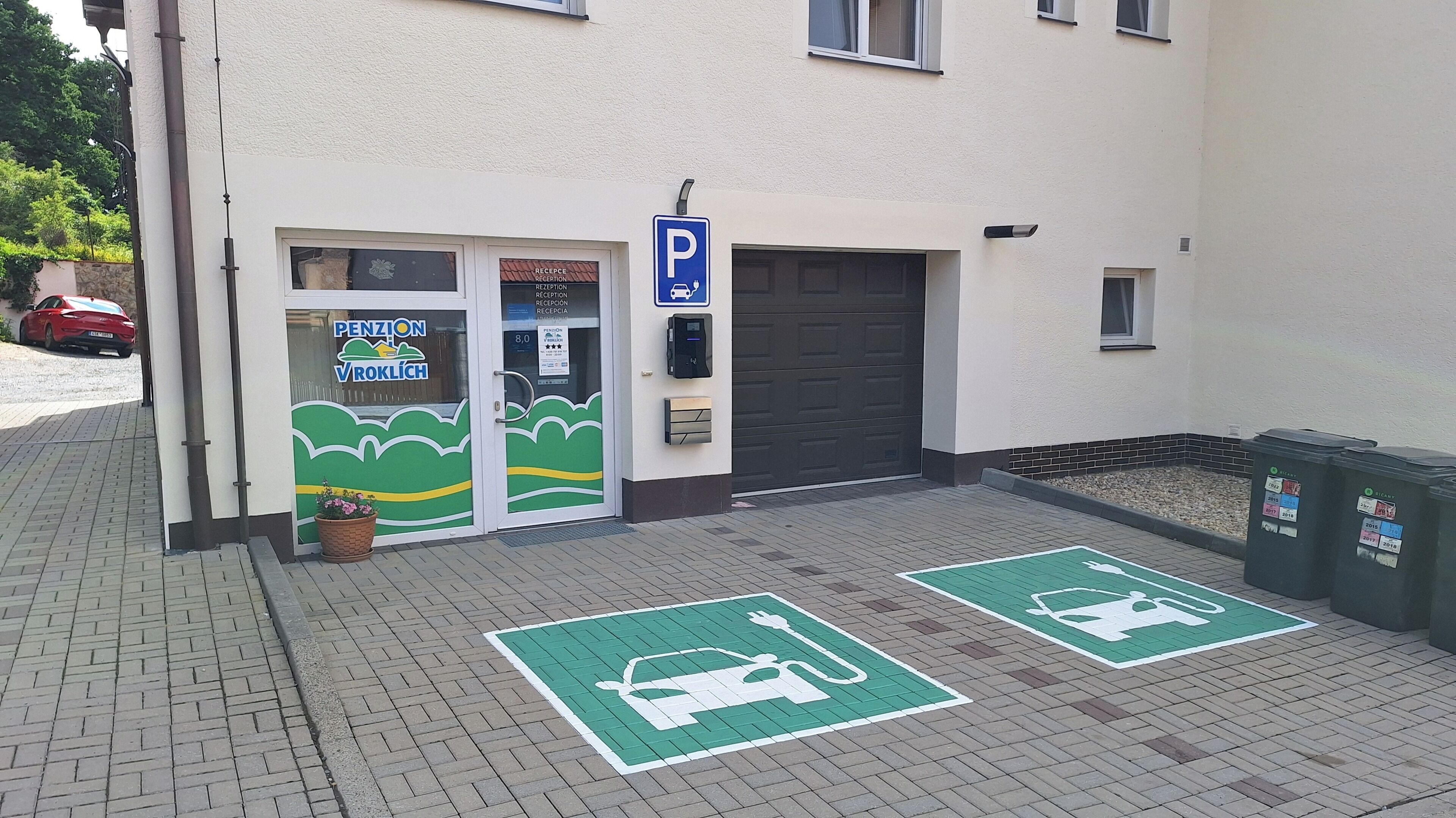 En bygning med receptionsområde, parkeringsskilt og ladestandere til elbil.