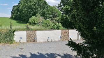 A parking area with stone walls and blue parking signs.