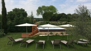 Un jardin avec un jacuzzi, un espace salon extérieur et un escalier en bois.