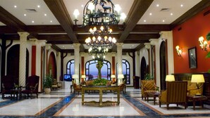A lobby with a marble floor, a central chandelier, and seating arrangements. - Helnan Auberge Hotel (Sinnuris)