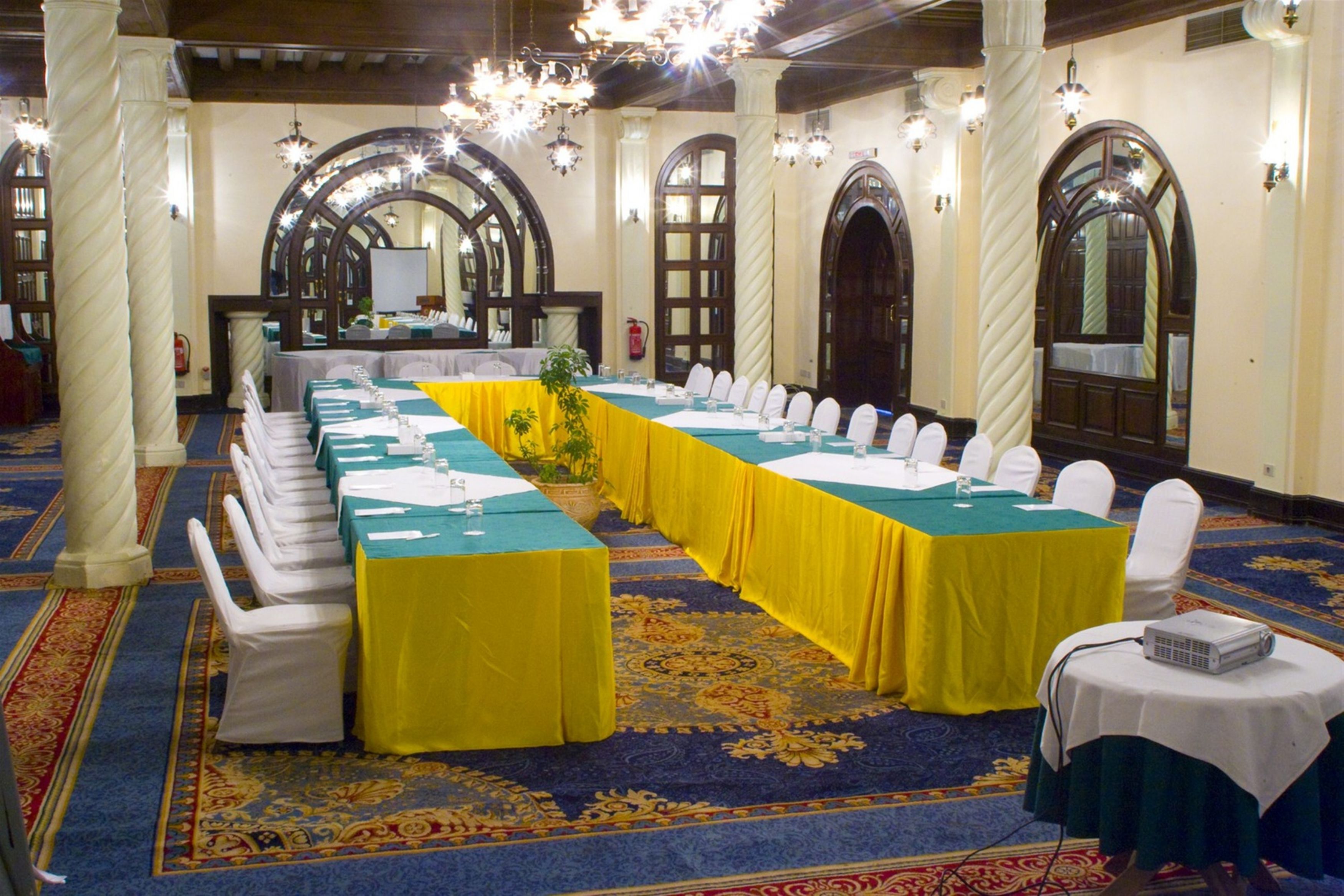 A conference room with a long table, white chairs, and a projector.