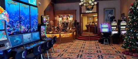 A gaming area with multiple screens, a Christmas tree, and a patterned carpet.