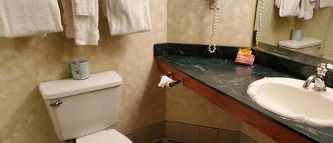 A bathroom with a toilet, sink, and towel rack.