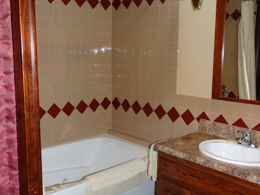 Un bagno con una vasca, un lavandino e uno spazio doccia.