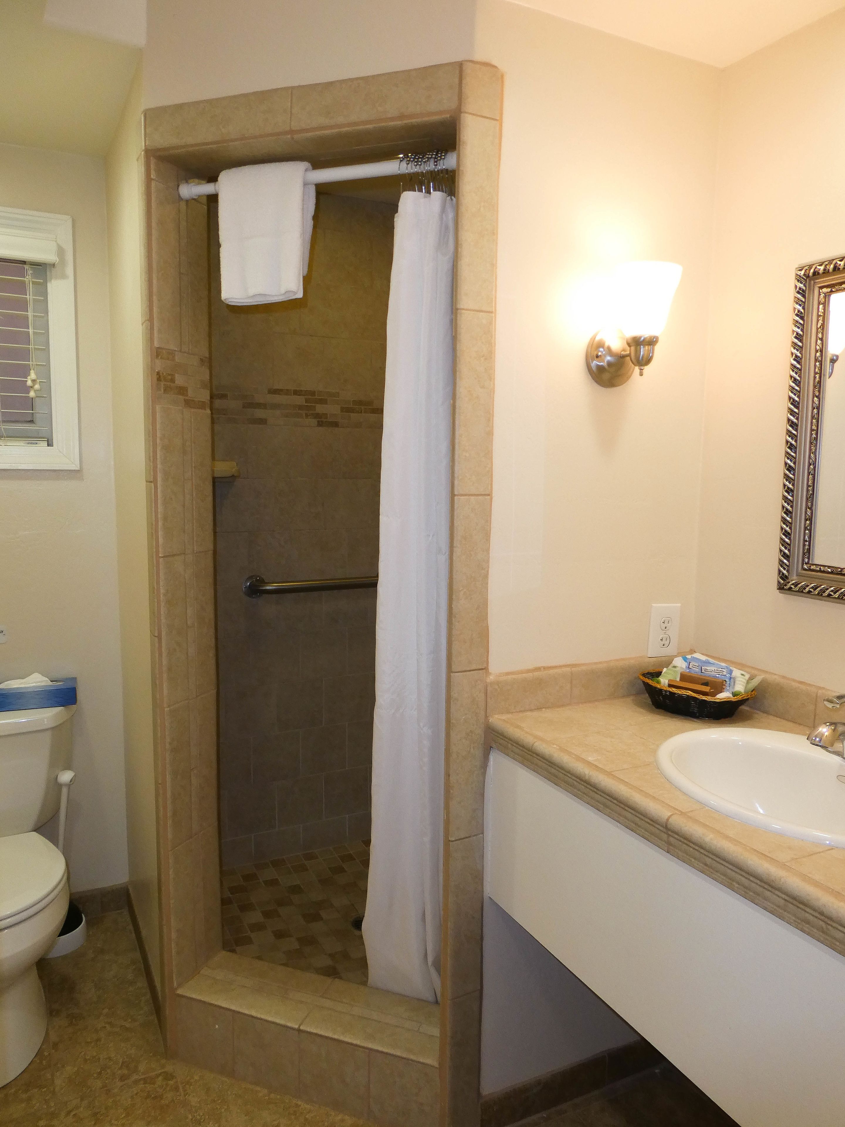 A bathroom with a shower, toilet, and sink.