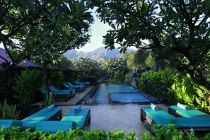 Un espace piscine avec des chaises longues et une vue sur les montagnes.