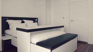Une chambre moderne avec un lit superposé, une table de chevet et une porte.