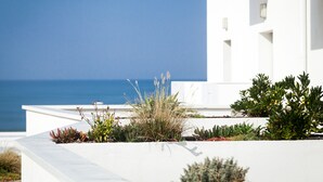 Un bâtiment blanc doté d’une terrasse-jardin qui offre une vue sur la mer.