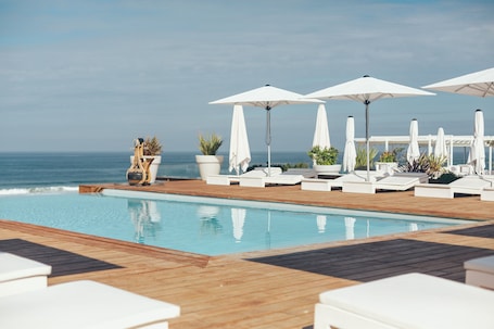 Una piscina al aire libre de temporada, sombrillas
