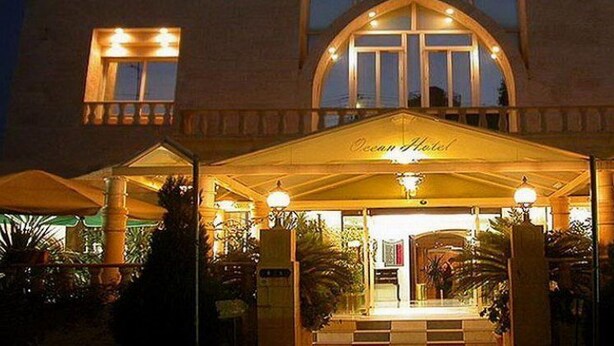L’entrée d’un hôtel, avec un porche abrité, une enseigne indiquant « Ocean Hotel » et une façade bien éclairée.