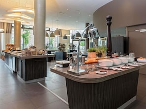 Um balcão de café da manhã moderno com diversas opções de alimentos e uma estação de café.