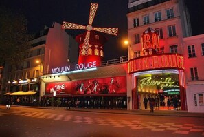 A building with illuminated signs for Moulin Rouge and Feeric Feeri.