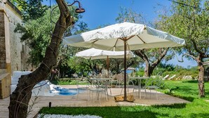 A wooden deck with outdoor furniture, a pool, and a garden area with white pebbles. - Badia del Casale (Ugento)