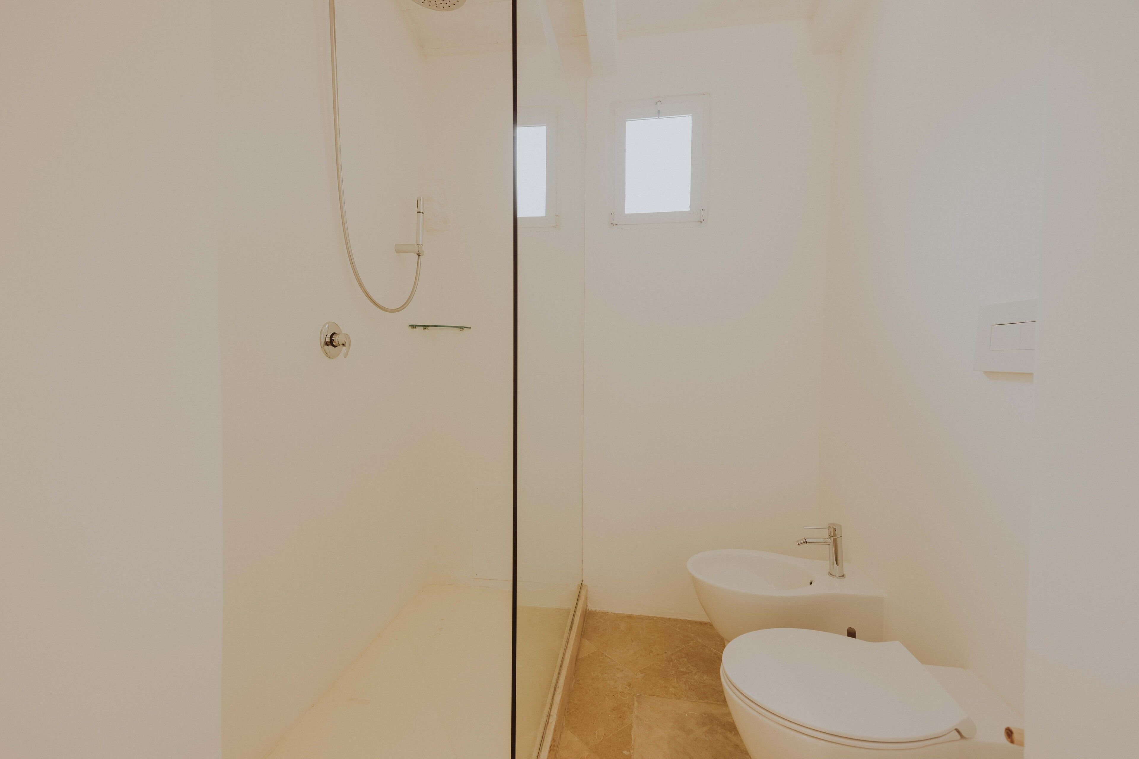Baño con ducha, inodoro y lavamanos.