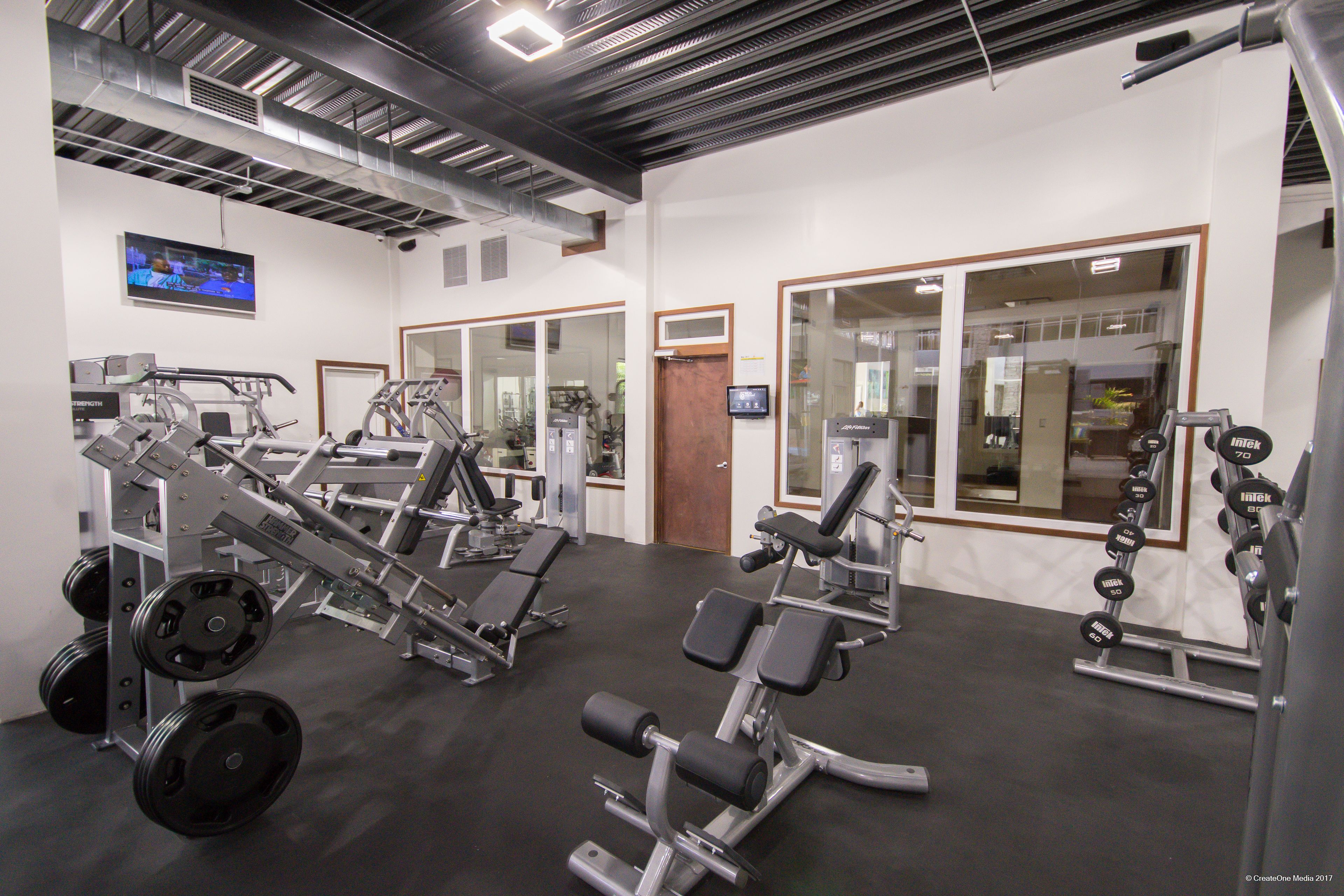 A gym with various exercise equipment, including weight machines and dumbbells.