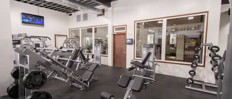 A gym with various exercise equipment, including weight machines and dumbbells.