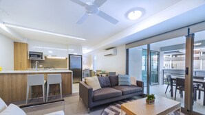Un apartamento moderno con kitchenette, sofá, comedor y balcón con vistas.