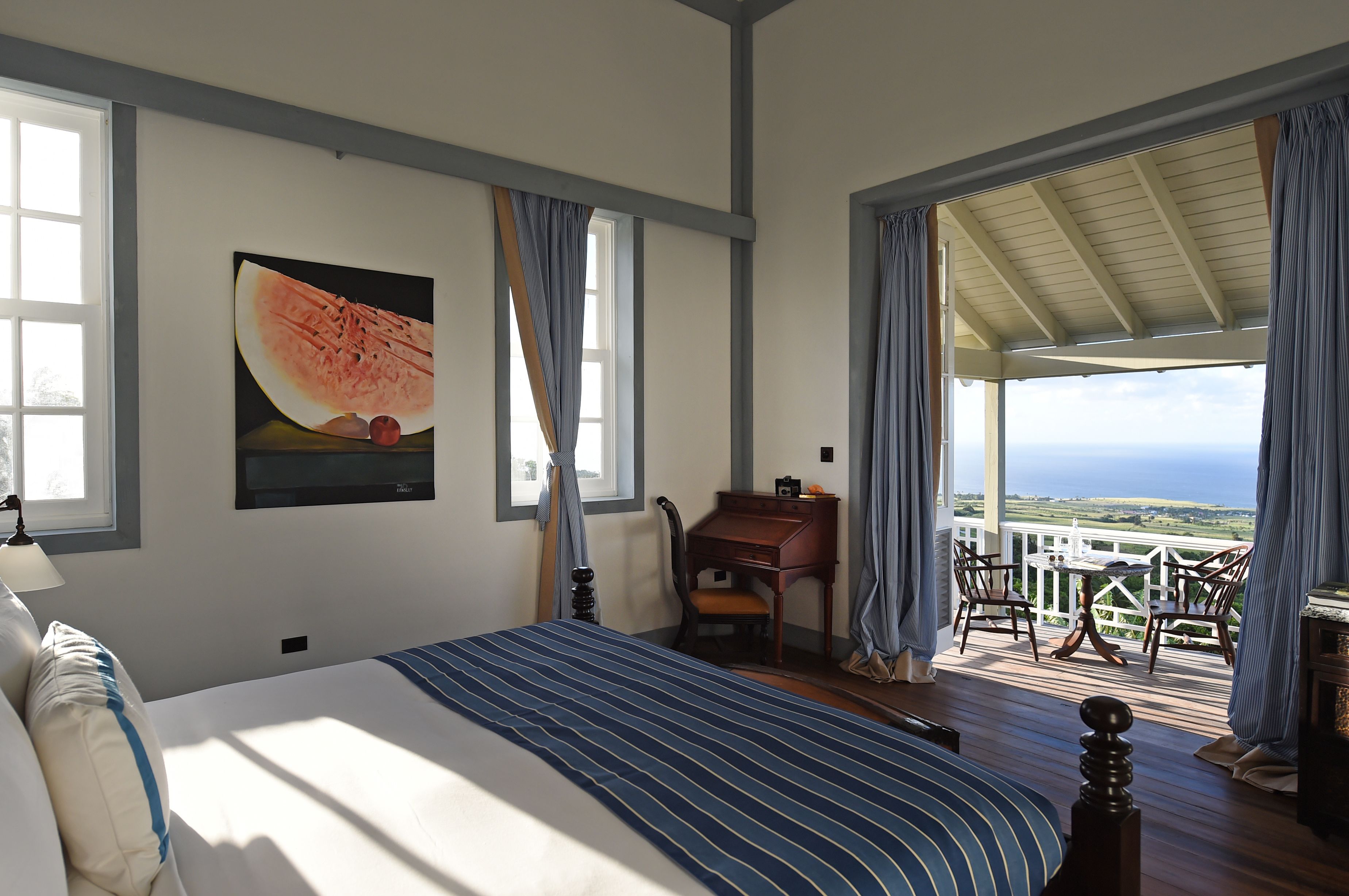 Un dormitorio con una cama grande, un escritorio y vistas al exterior.