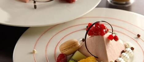 Dos platos de postre con varias frutas y un vaso de bebida.