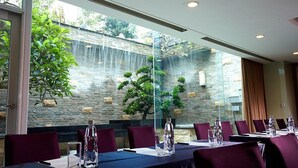 A conference room with a stone wall and a waterfall view. - Yuh Tong Hotel (Chiayi City)