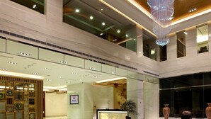 A spacious lobby with a high ceiling, a large chandelier, and a reception desk. - Yuh Tong Hotel (Chiayi City)