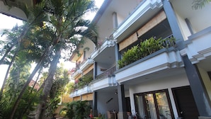 A multi-story building with balconies, outdoor seating, and bicycles. - Taman Agung Hotel (Denpasar)