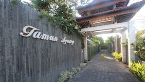 A pathway leading to a building with a sign reading "Taman Agung". - Taman Agung Hotel (Denpasar)