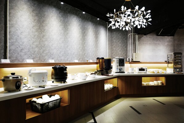 A modern kitchen with a central island, various appliances, and a unique light fixture.