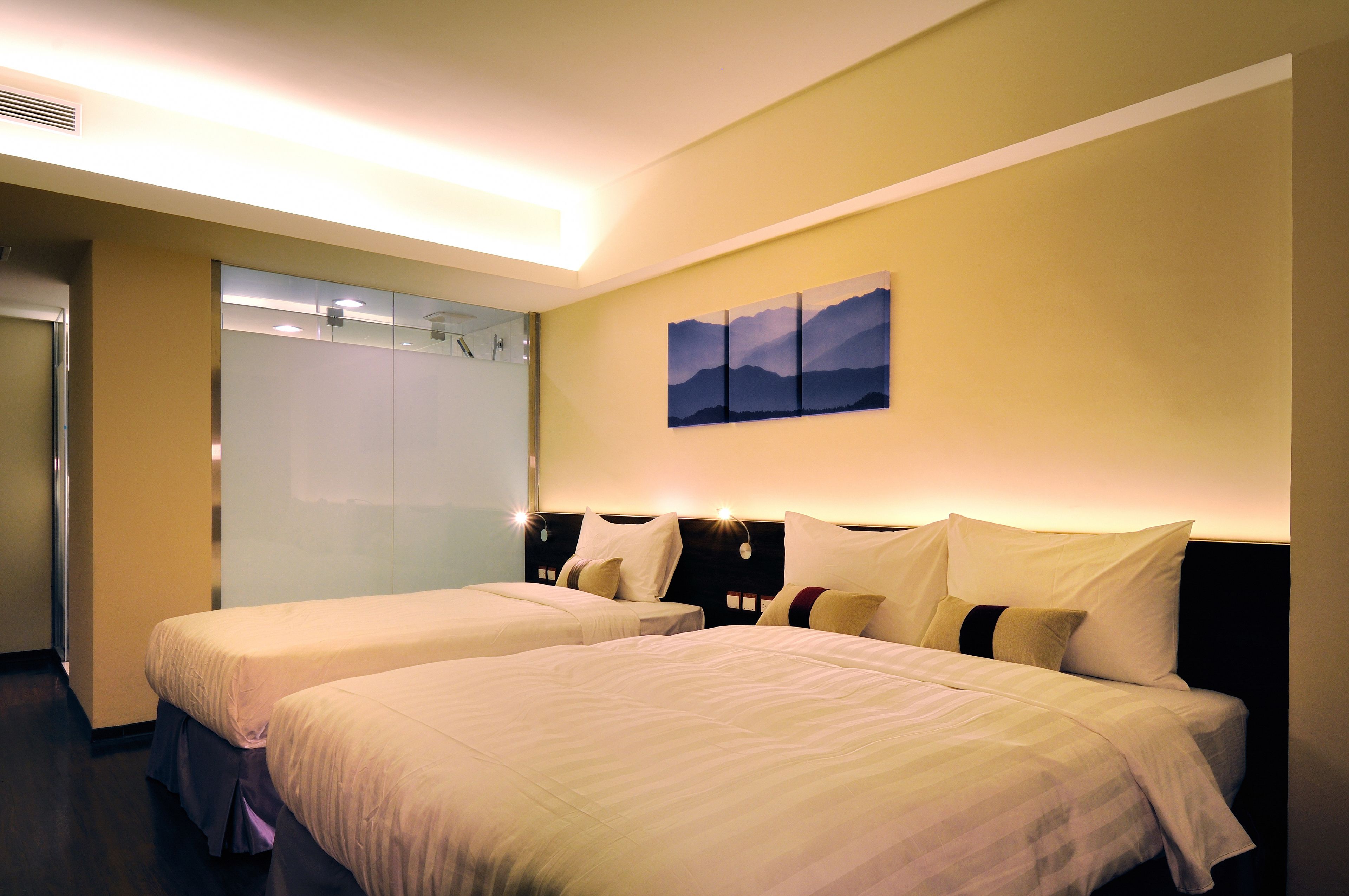 A hotel room with two beds, a wardrobe, and a painting on the wall.
