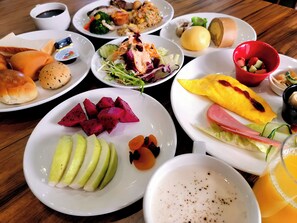 A table with various dishes including fruit, vegetables, and a drink.