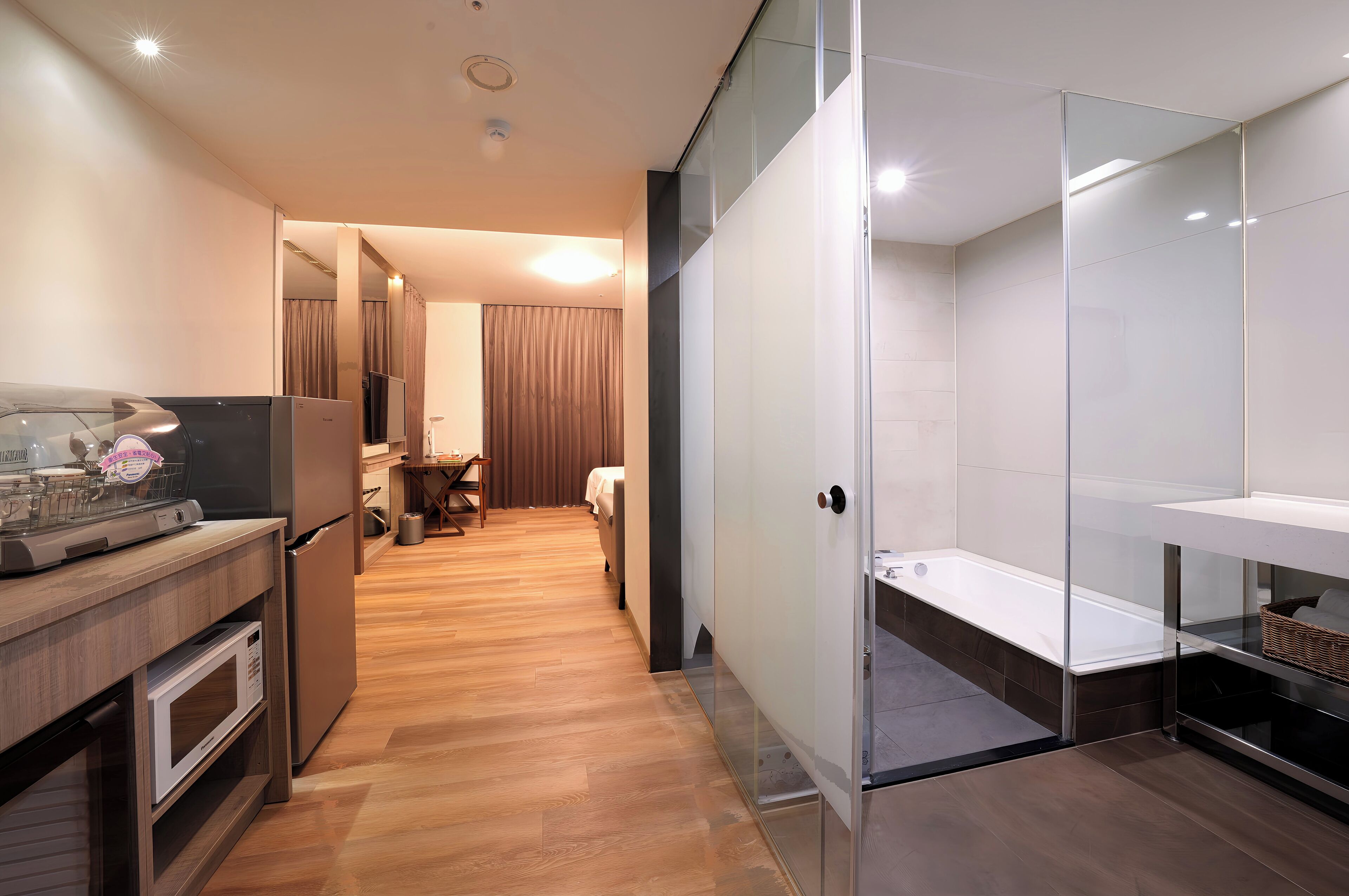 A modern kitchen with a microwave, refrigerator, and a dining area with a table and chairs.