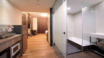 A modern kitchen with a microwave, refrigerator, and a dining area with a table and chairs.