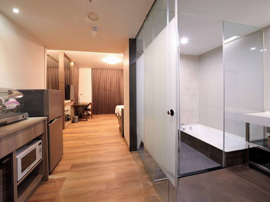A modern kitchen with a microwave, refrigerator, and a dining area with a table and chairs.