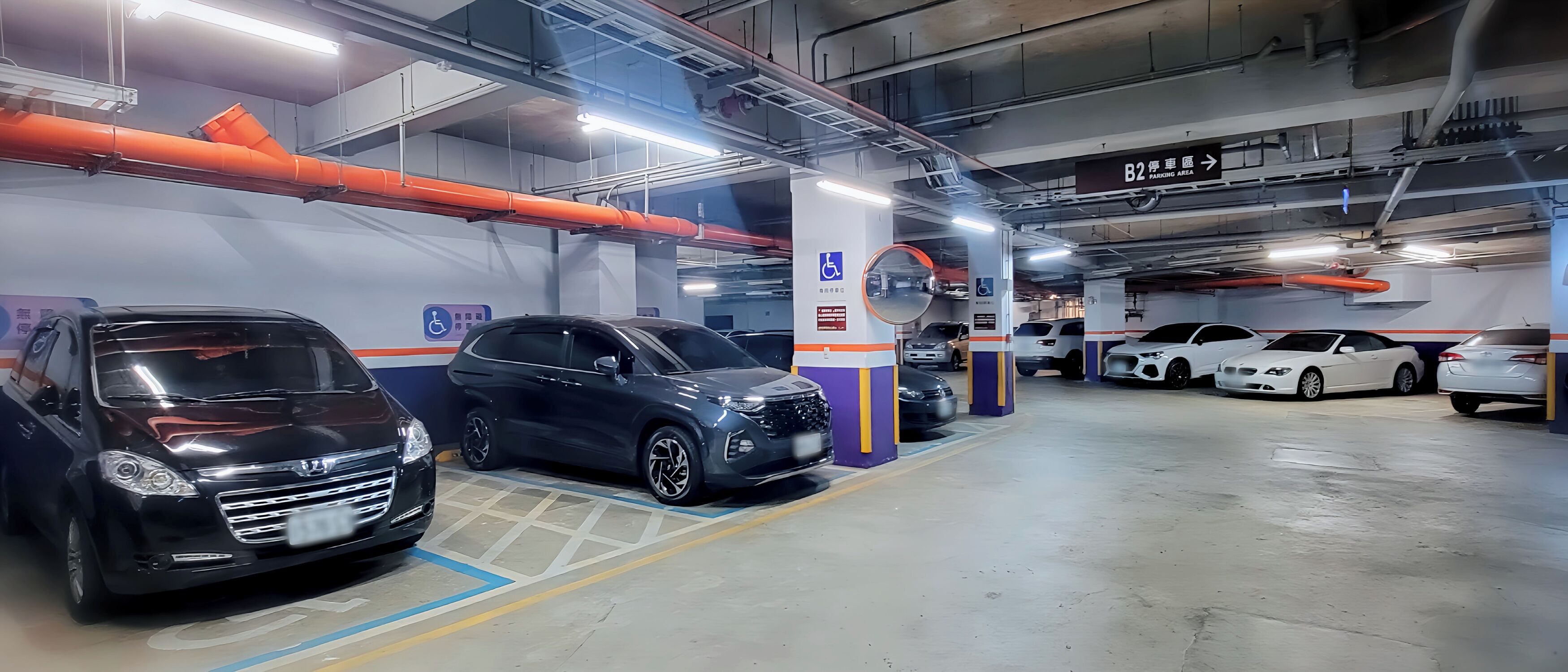 A multi-level parking garage with cars parked in designated spaces, including a handicapped parking spot.