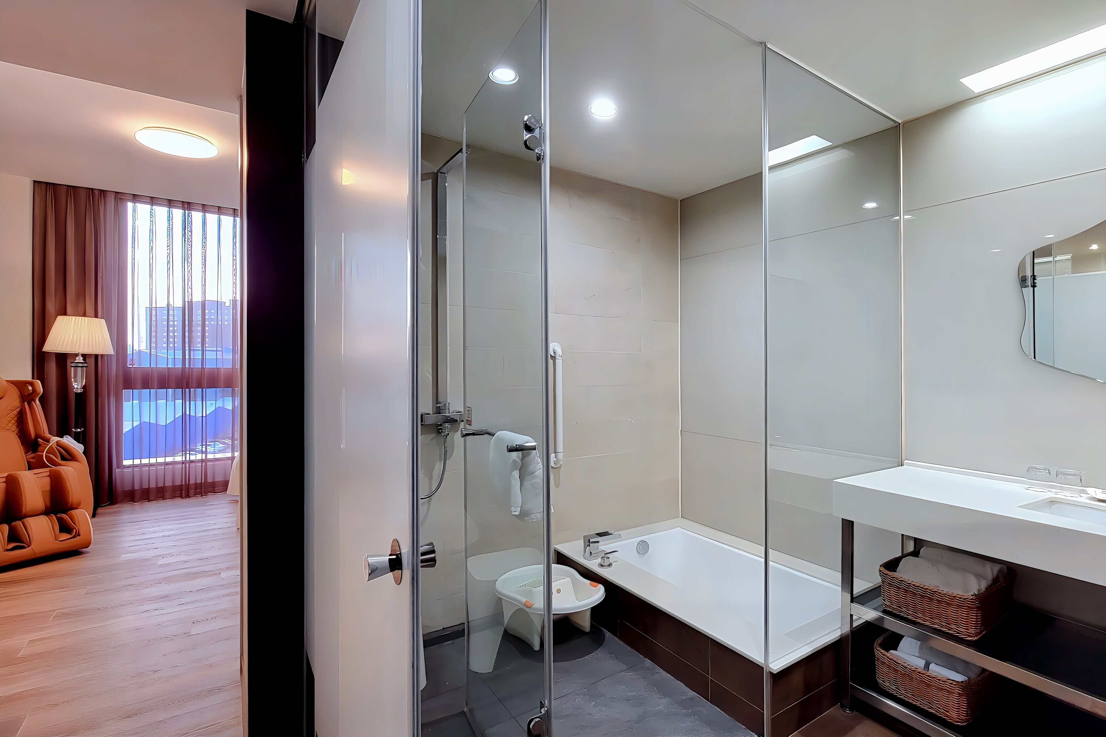 Une salle de bain moderne avec une douche à l’italienne en verre, des toilettes blanches et une baignoire.