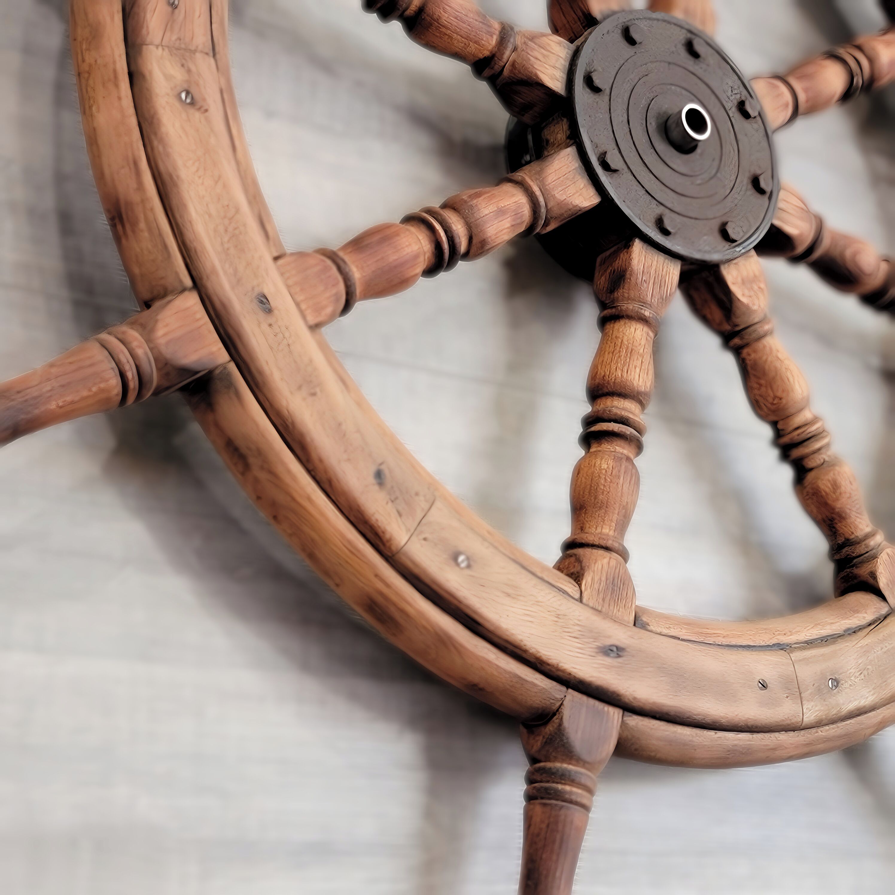 A wooden ship's wheel with a central hub and spokes.