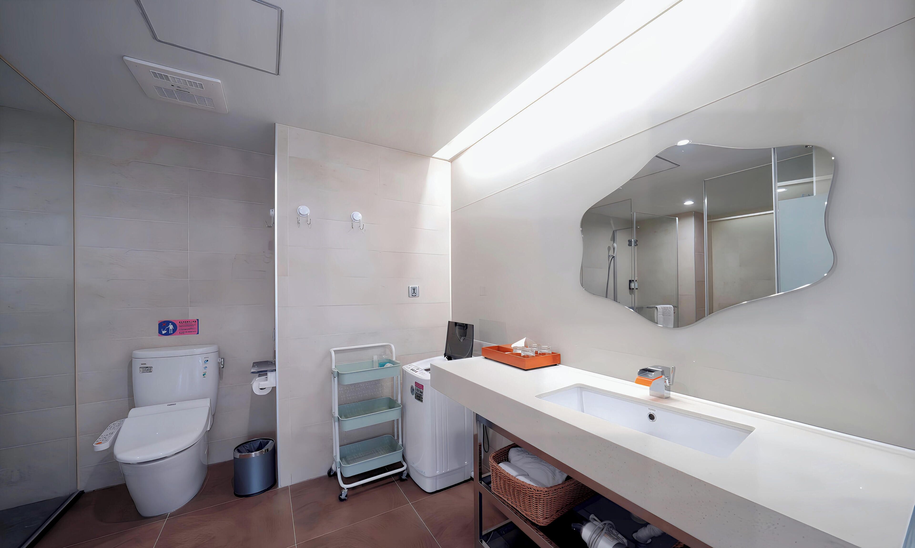 A modern bathroom with a toilet, bidet, and a large mirror.