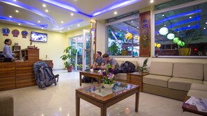 A hotel lobby with a reception desk, seating area, and large windows. - Aryatara Kathmandu Hotel (Kathmandu)