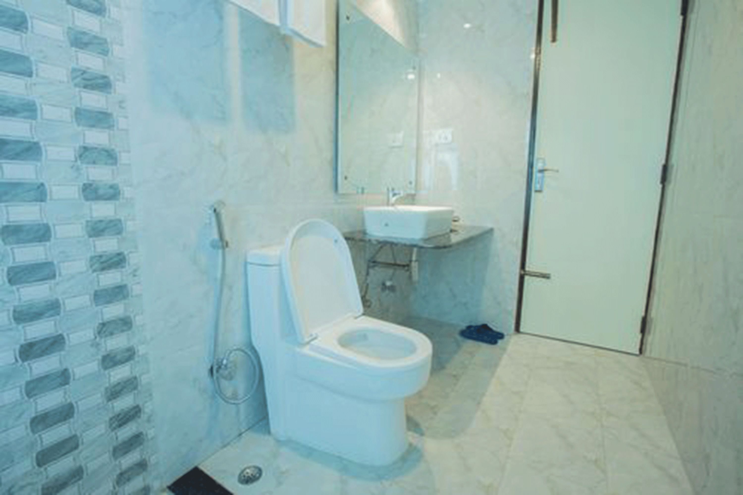 A bathroom with a white toilet, a sink, and a mirror.