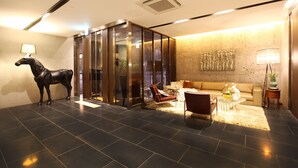 Eine moderne Lobby mit einer großen Skulptur eines Pferdes, einer Couch und einem Couchtisch.