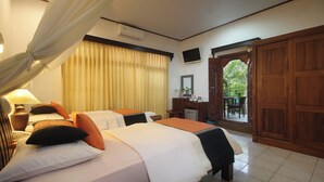 Habitación de hotel con dos camas, un escritorio, una silla, un televisor y vistas al exterior.