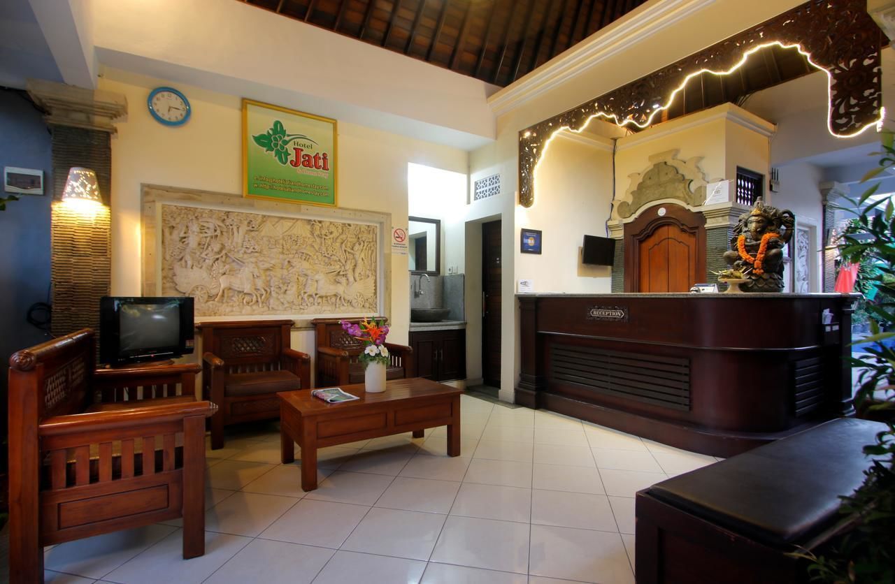 Um hall de hotel com mobiliário de madeira, um balcão de recepção e um mapa grande na parede.