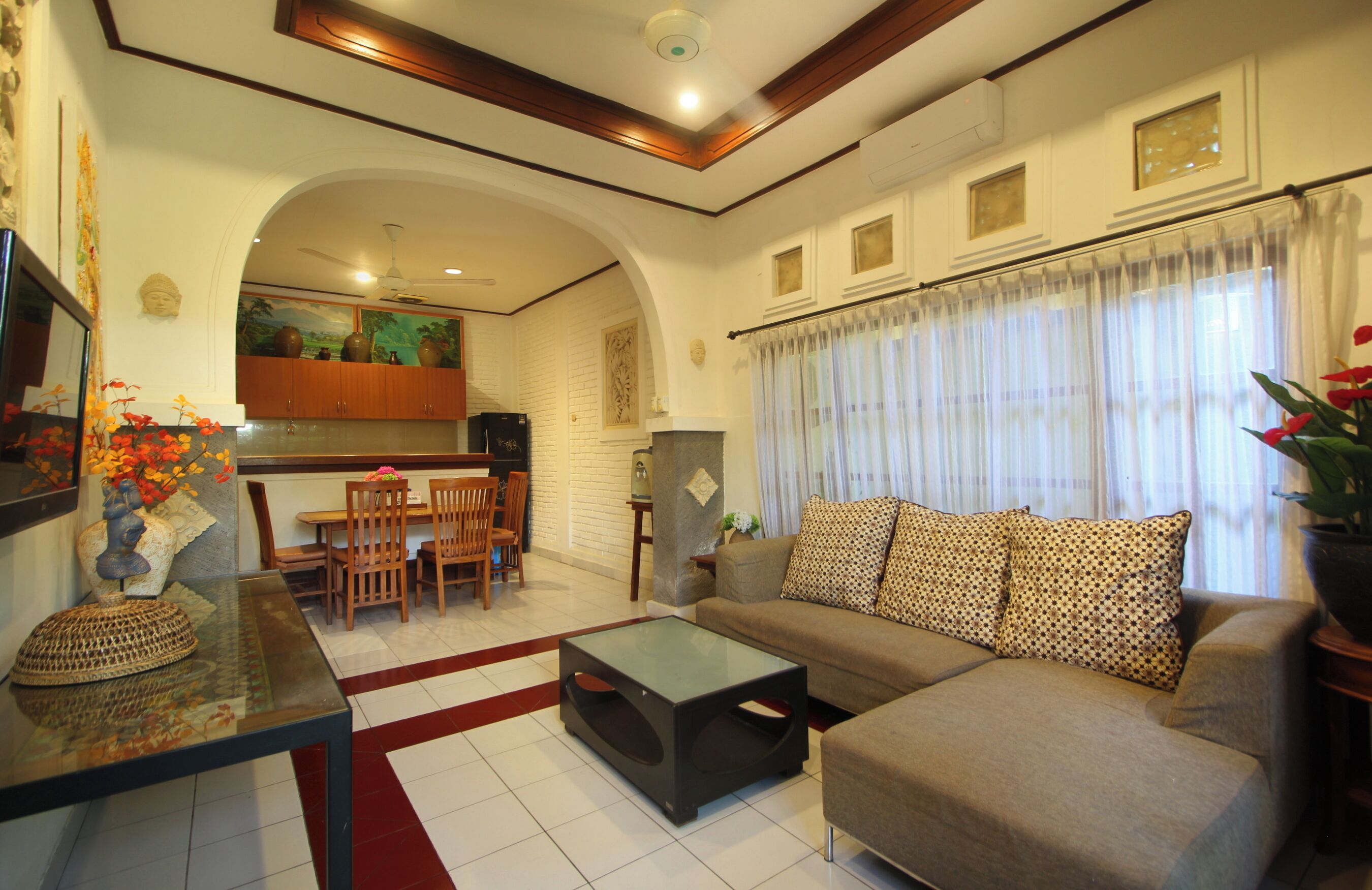Uma sala de estar com sofá, mesa de centro e um espaço de jantar com cadeiras e mesa.