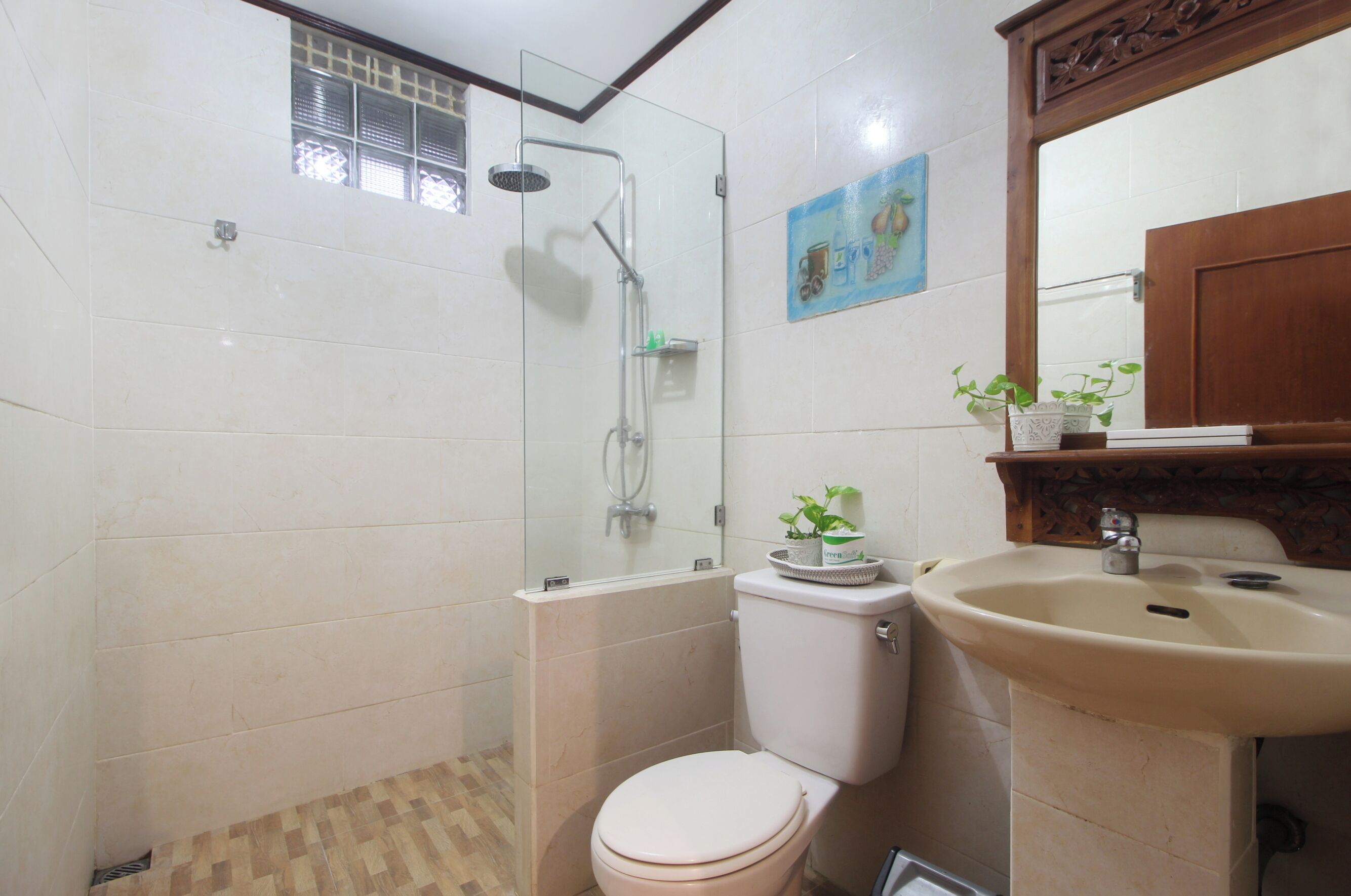 Un baño con ducha de mampara de vidrio, un inodoro y un lavabo.