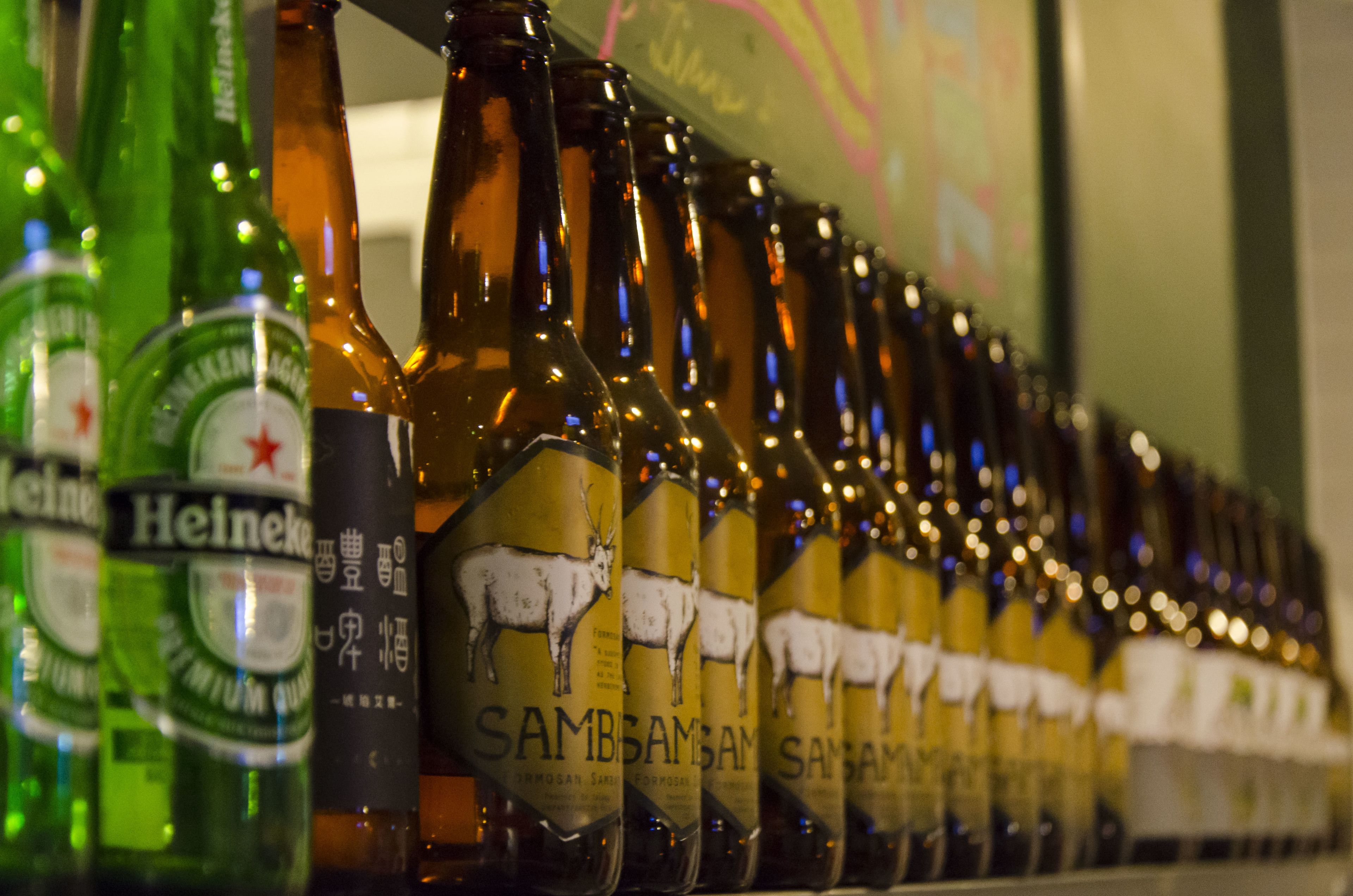 Varias botellas de cerveza con etiquetas, incluyendo las marcas Heineken y Sambsam.