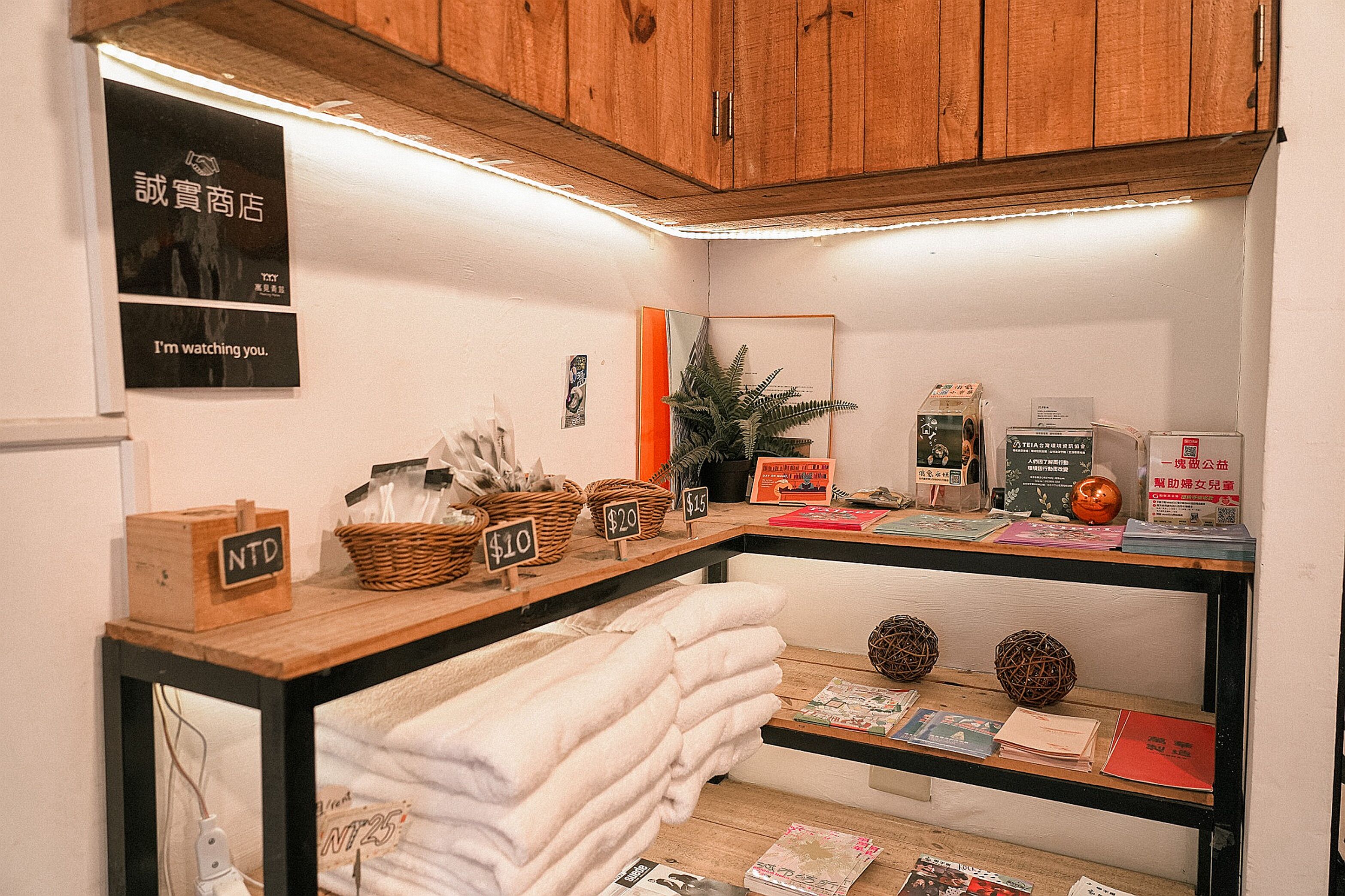 A wooden counter with baskets, price tags, and a mirror.