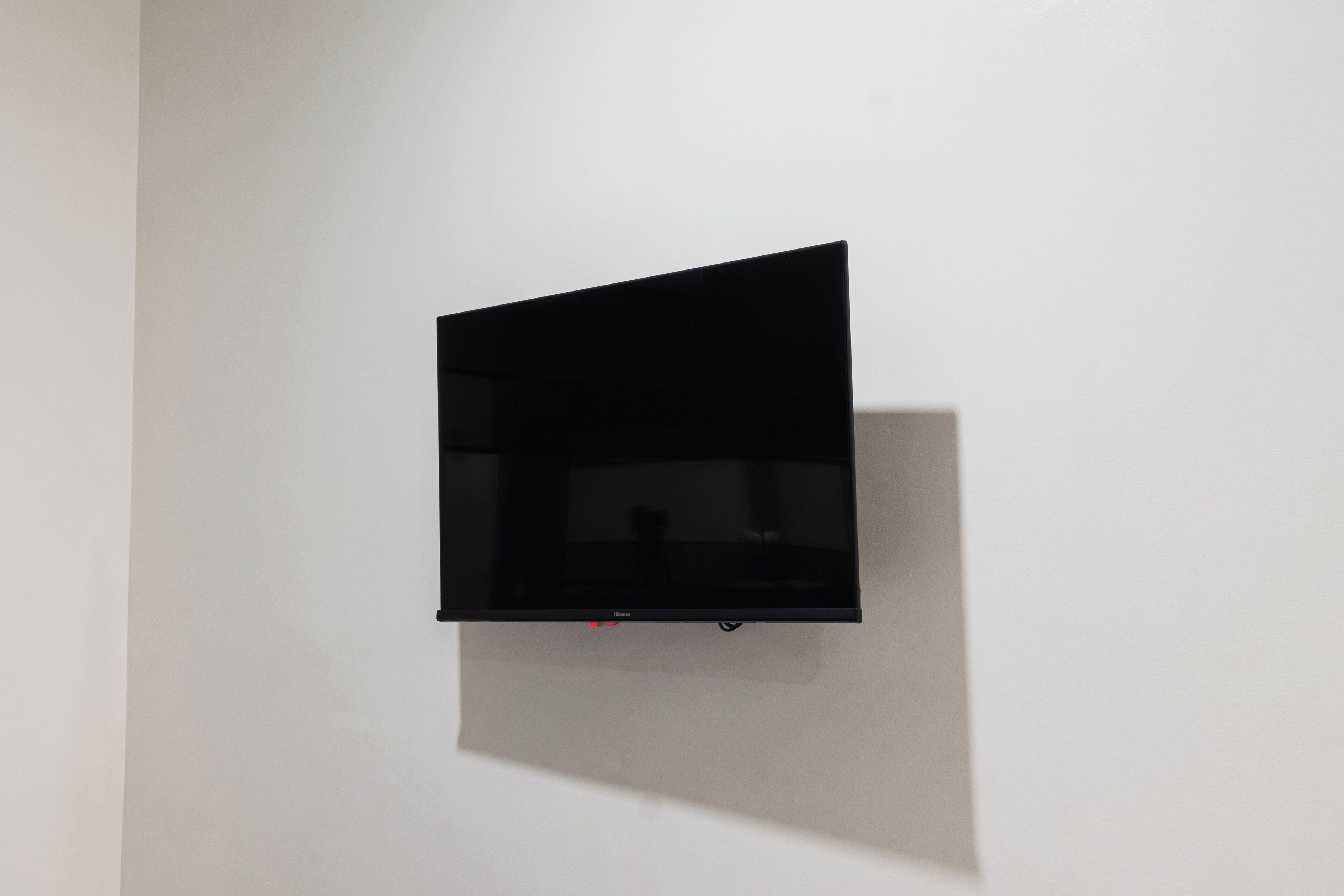 Un televisor negro montado en una pared blanca.